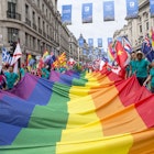 Pride in London parade participants carrying a huge rainbow flag along Regent Street