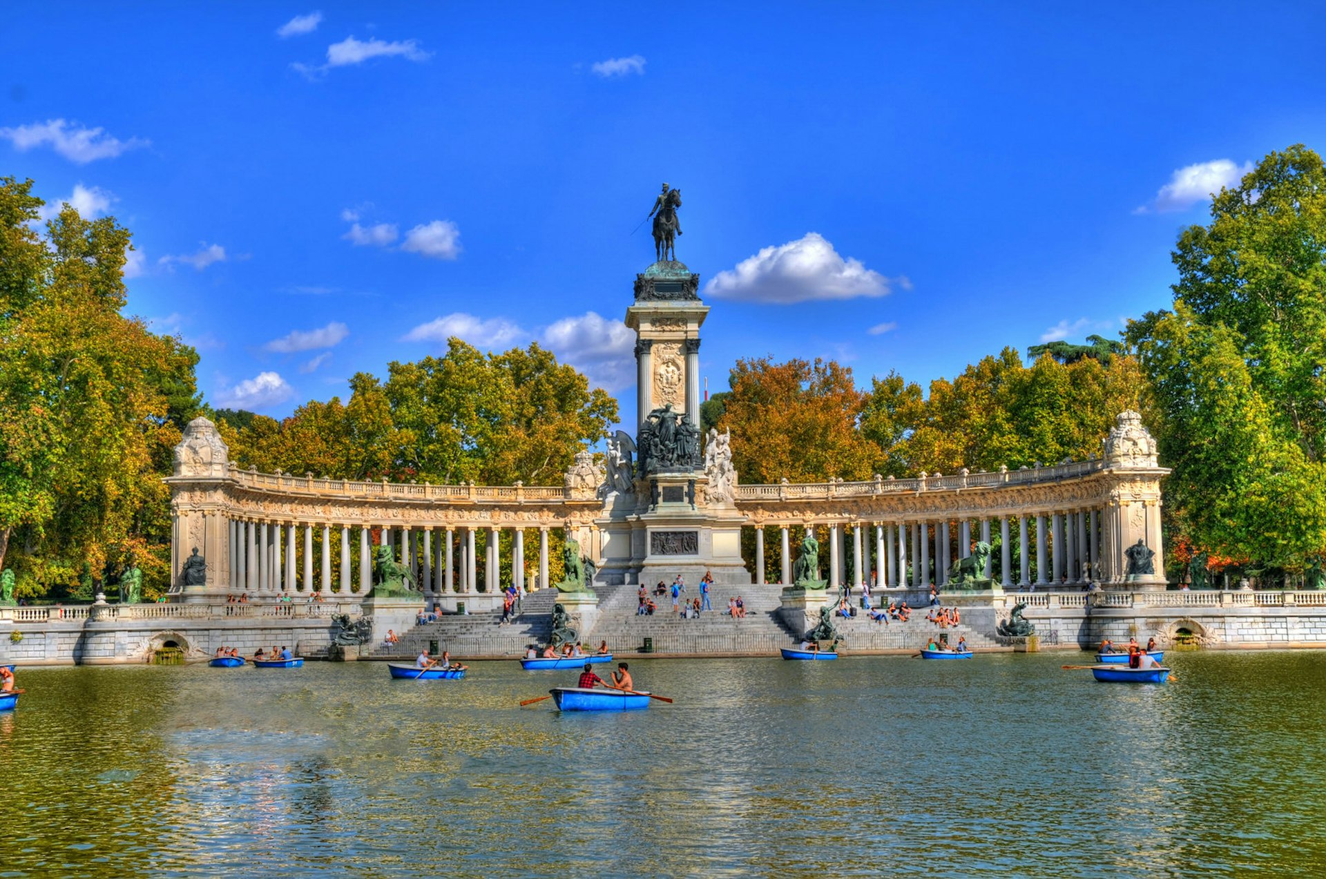 People in boats by the Monument to Alfonso XII in Madrid's Parque del Buen Retiro