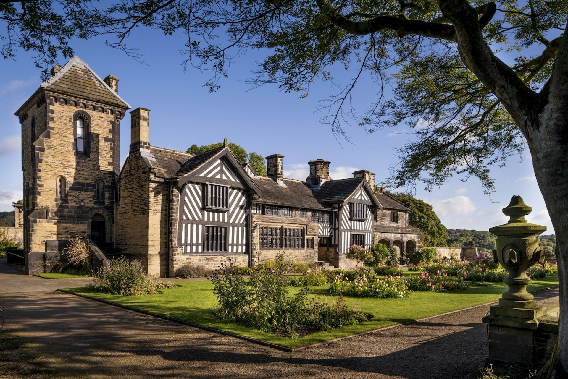 The exterior of Shibden Hall on a sunny day, featuring its Tudor half-timbered frontage