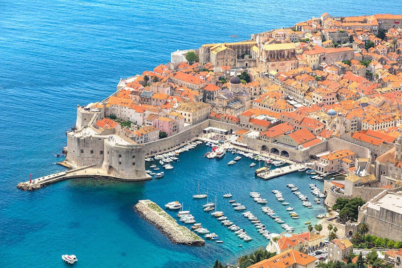 The coast of red-roofed Dubrovnik next to azure waters.