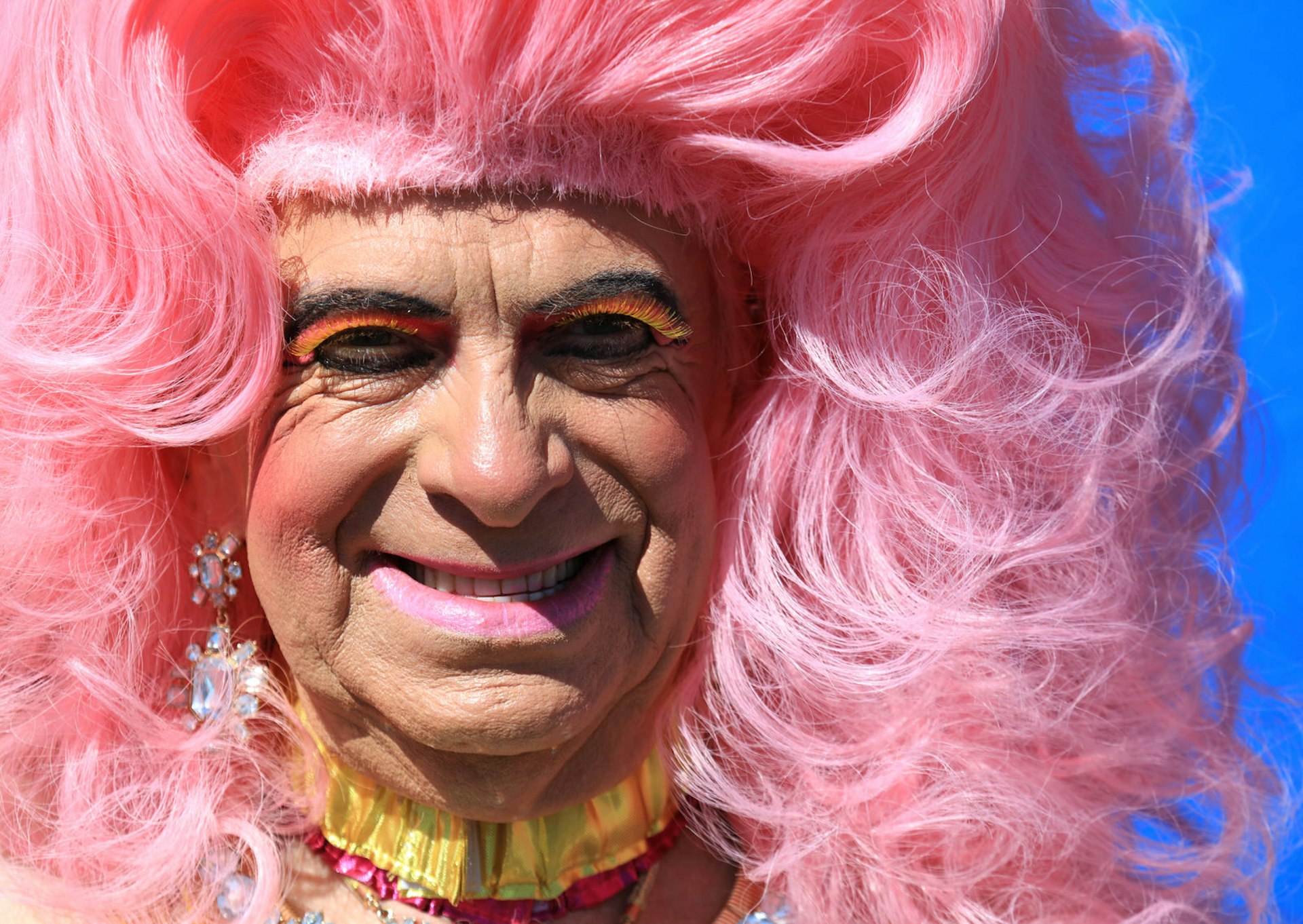 A happy Pridegoer rocks a huge pink wig and bright makeup