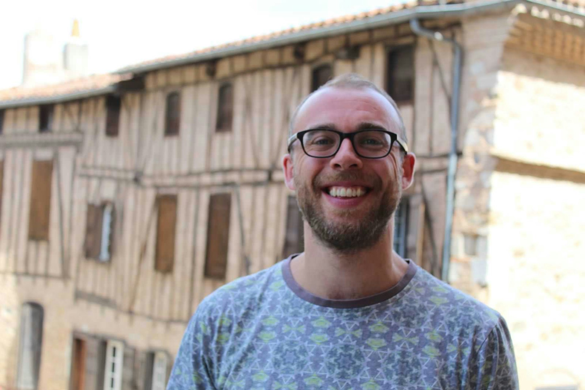 Tarn travel - Lonely Planet editor Tom Stainer in front of an old timber building in the Tarn region of France
