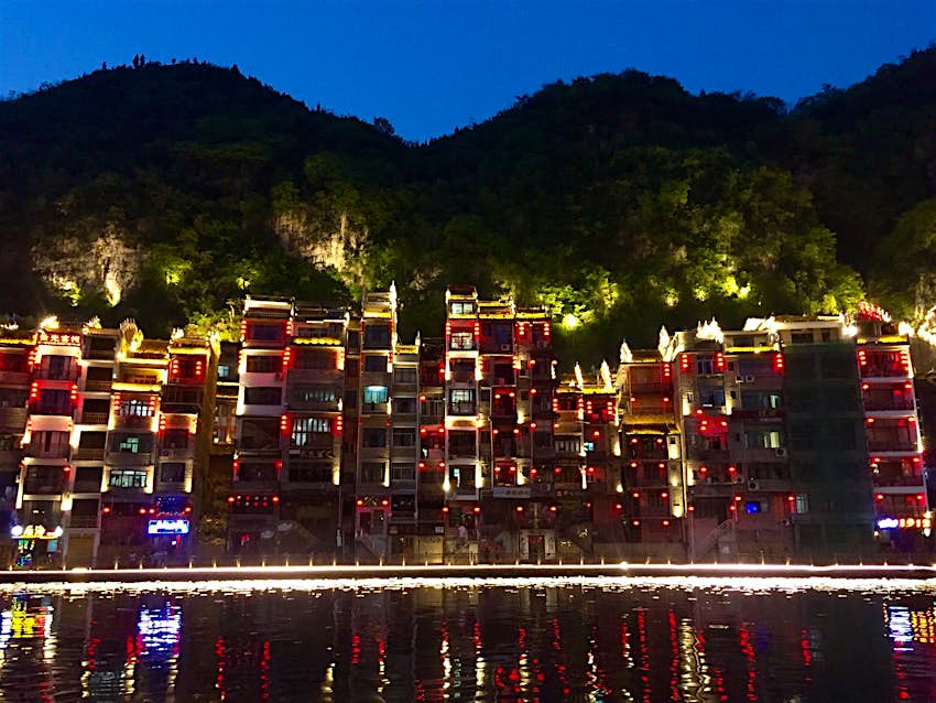 Evening lights reflected in the Wuyang River in Zhenyuan © Megan Eaves / Lonely Planet