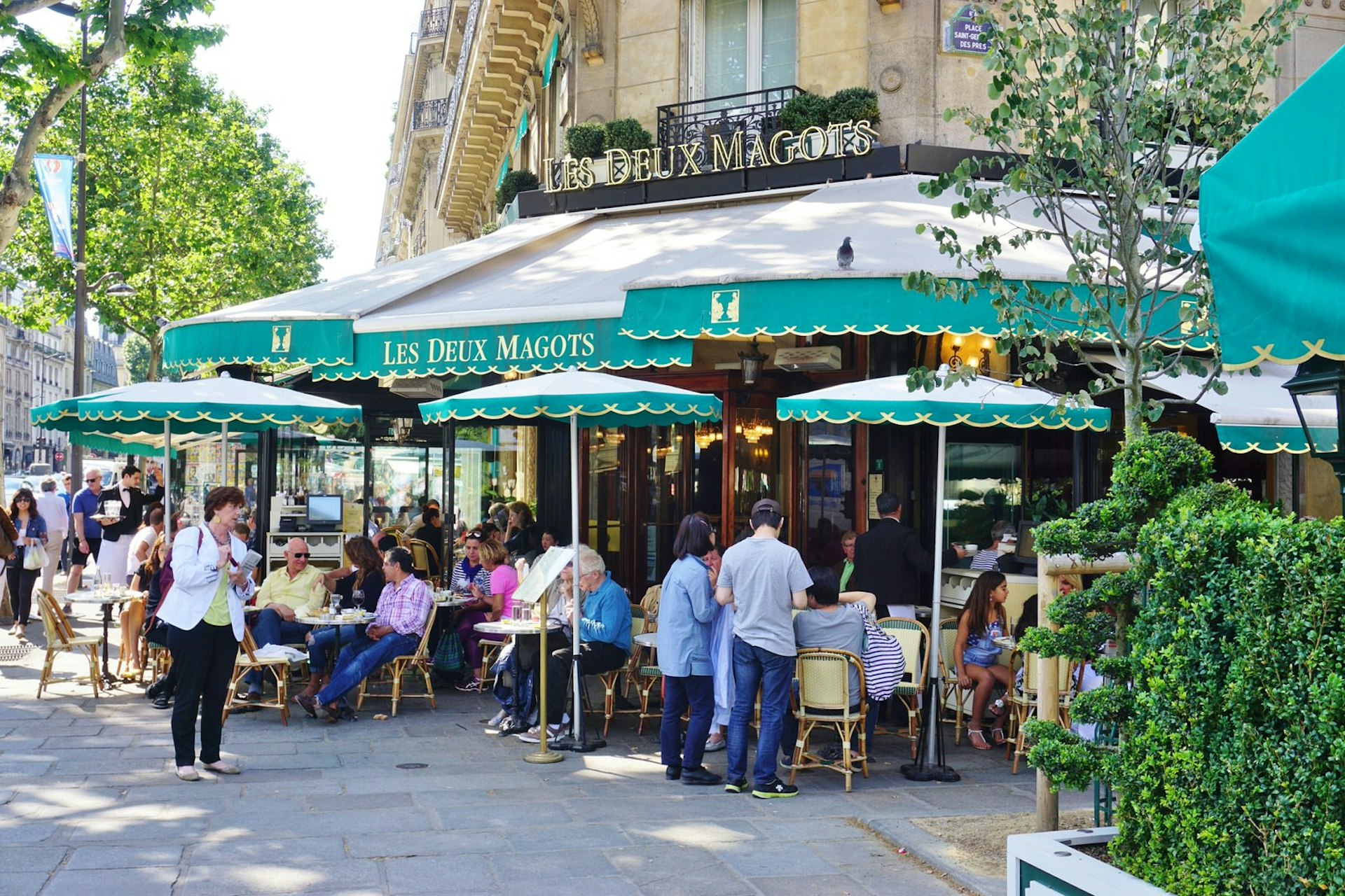 People sitting at tables at Les Deux Magots cafe in the 6th Arrondissement, Paris