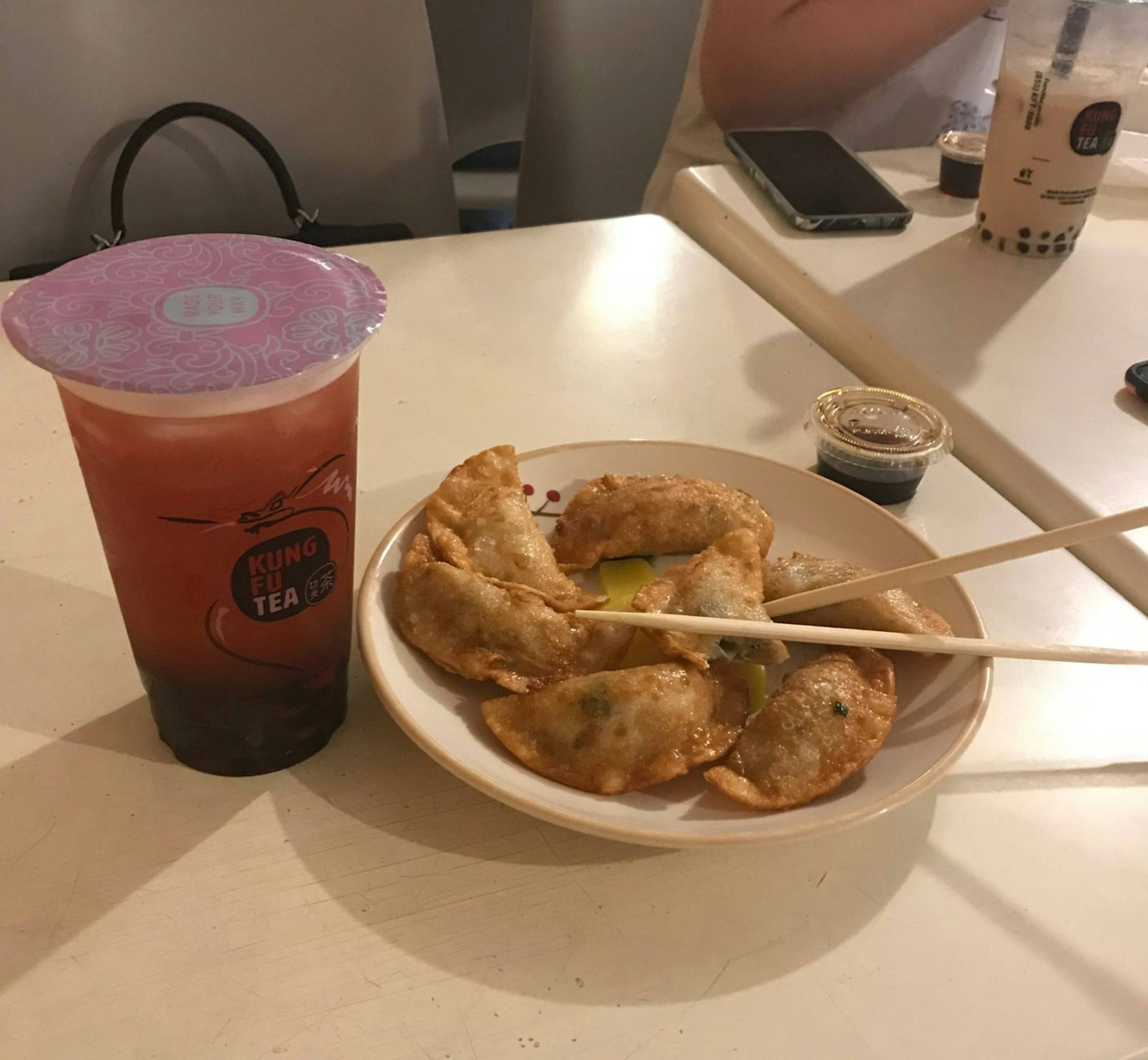 A strawberry green bubble tea from Kung Fu Tea, accompanied by some fried chicken dumplings. 