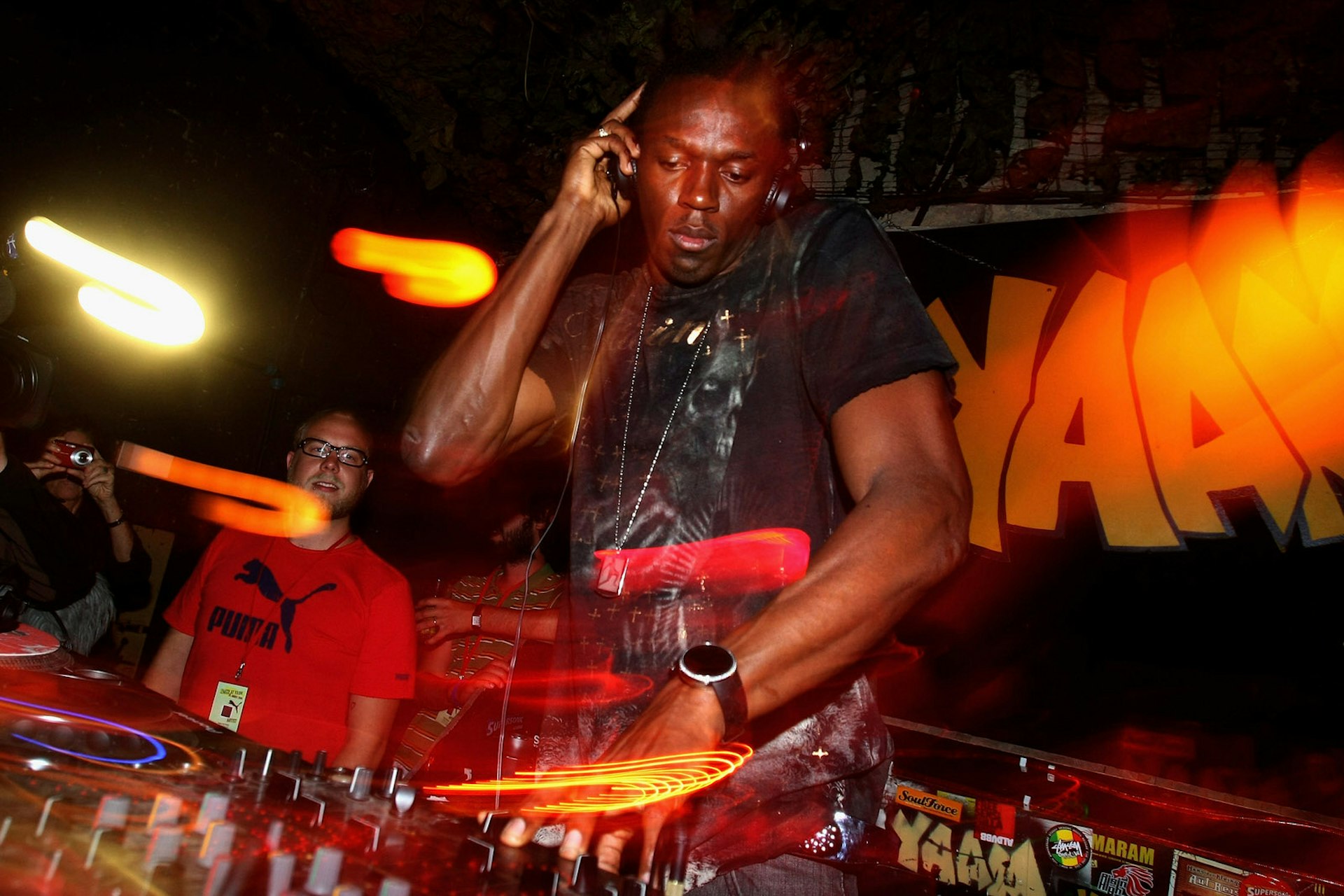 Berlin clubs - Usain Bolt celebrates his victories from the 12th IAAF World Championships in Berlin at the PUMA Party held at the Yaam Club. Bolt is at a DJ deck, touching his headphones with one hand