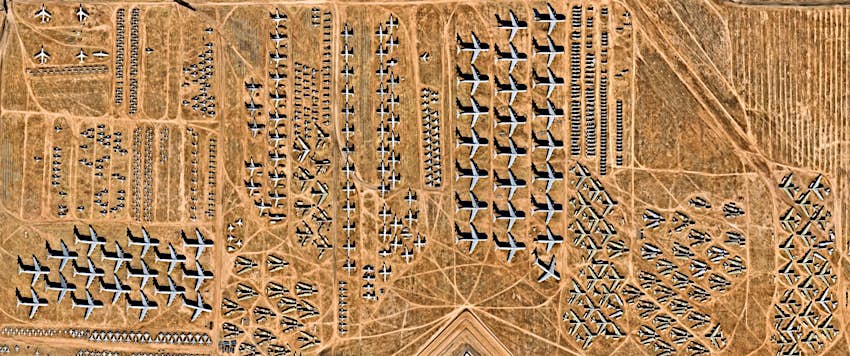 An overhead view of the desert shows dozens and dozens of abandoned airplanes in the desert near Davis–Monthan Air Force Base in Arizona