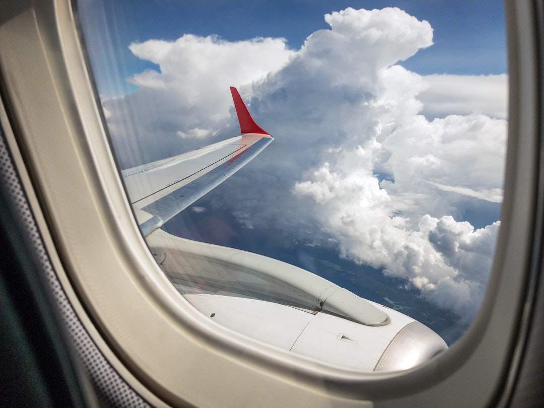 Thick clouds outside an airplane window; what causes airplane turbulence