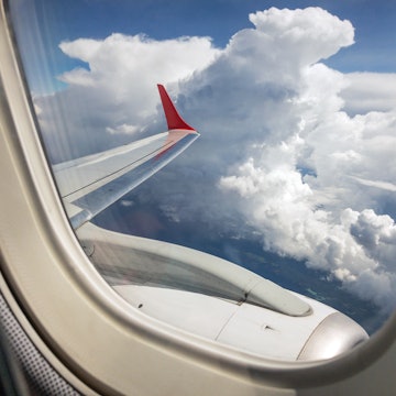 Thick clouds outside an airplane window; what causes airplane turbulence