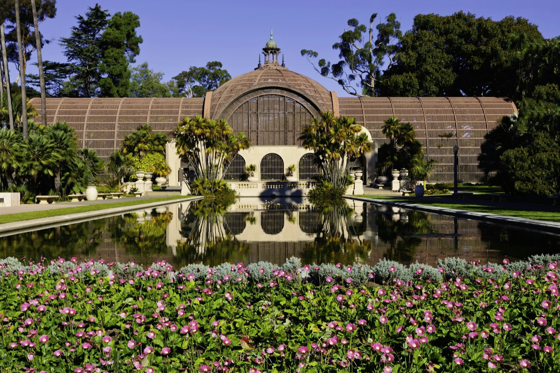 A domed building in lath is mirrored in the lily pond stretching out in front a great sight on a perfect weekend in San Diego