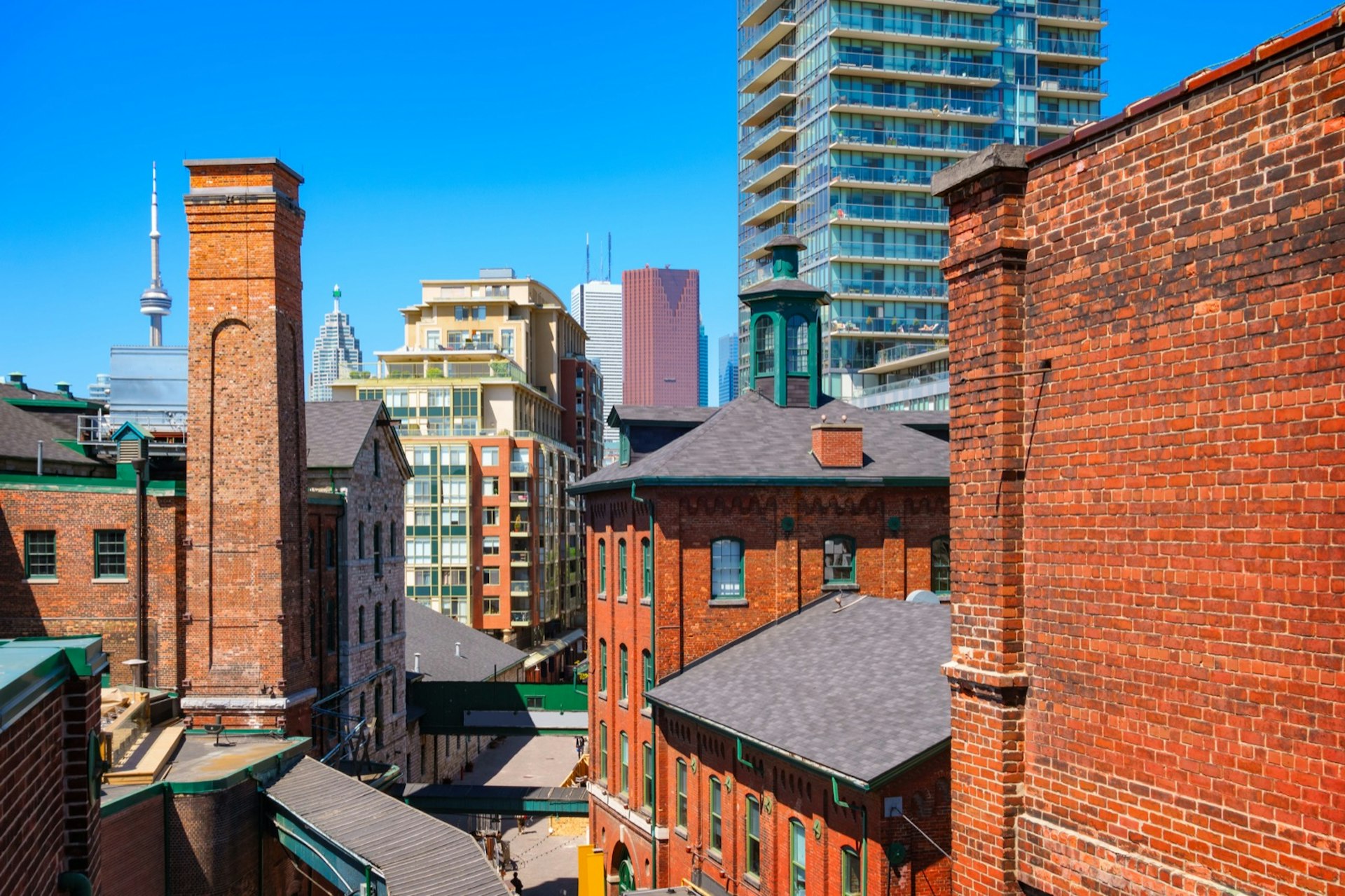 Photo of old brick towers of the chic Distillery District with new condos and downtown skyscrapers in the background 
