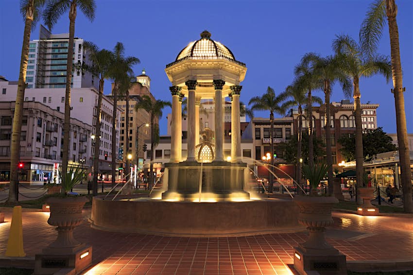 Broadway fountain in the Horton Plaza Park is a fountain surrounded by palm trees and buildings on a perfect weekend in San Diego