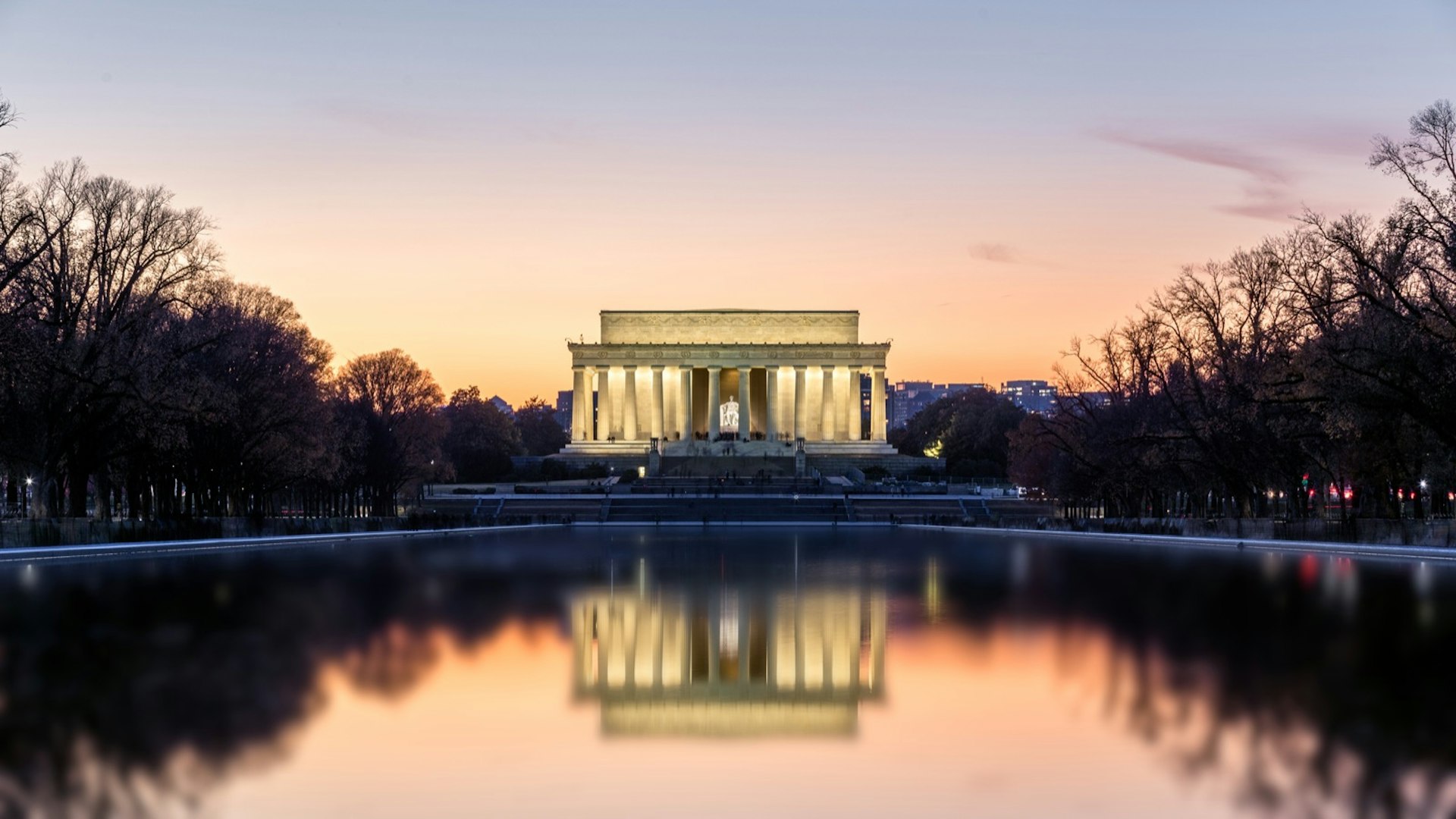 The Lincoln Memorial lit up at night reflected in the pond below. A trip to Washington isn't complete without a selection from the audiobooks for US road trips. 
