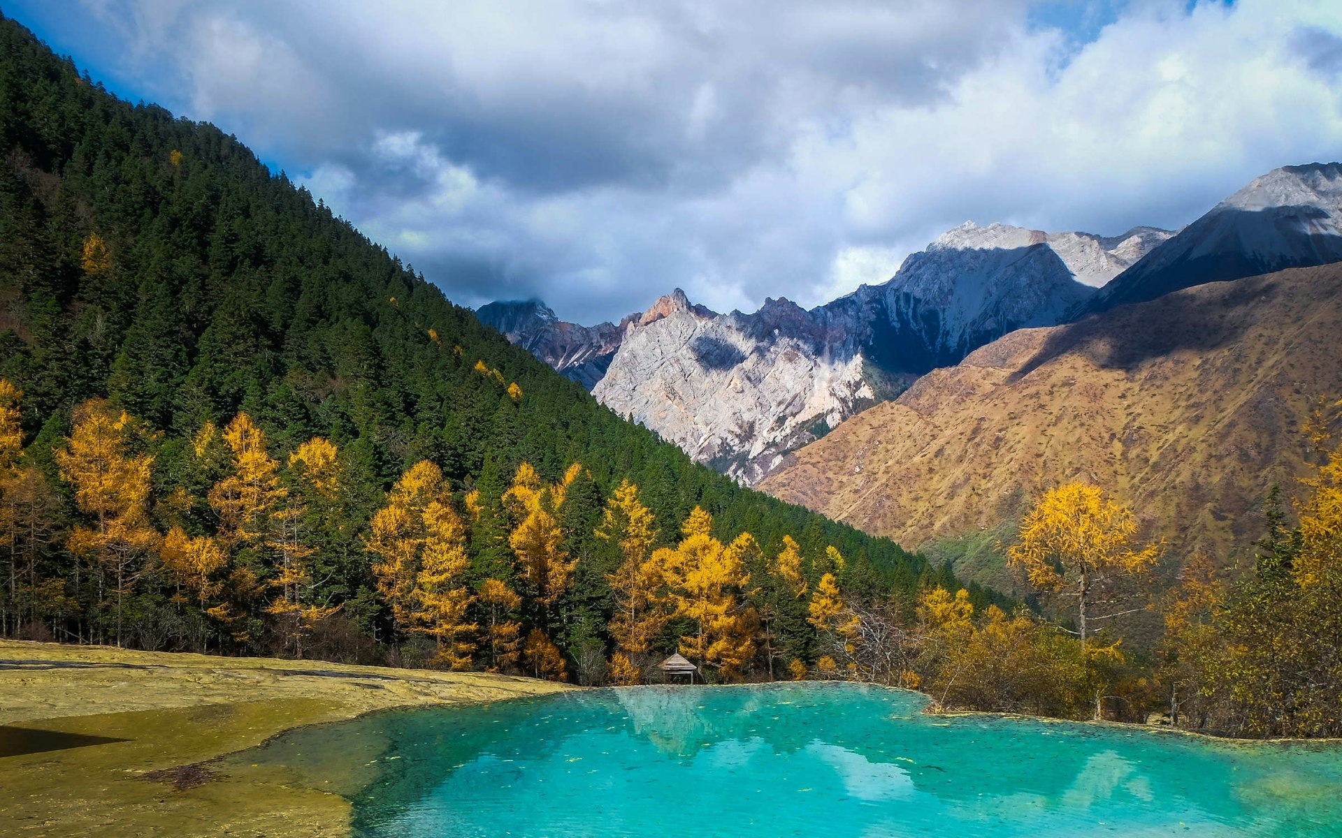 An emerald lake and mountains in autumn. 