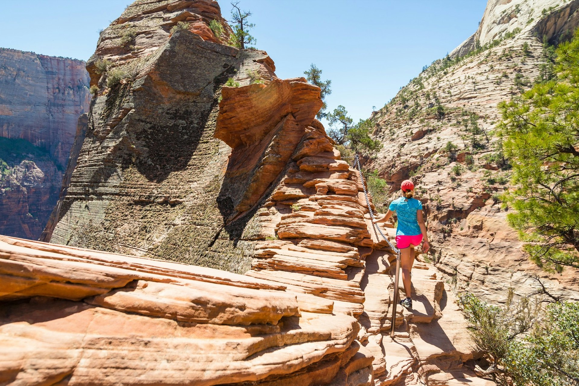 A young woman hikes along the ridge along the Angel's Landing trail in Zion National Park, Utah