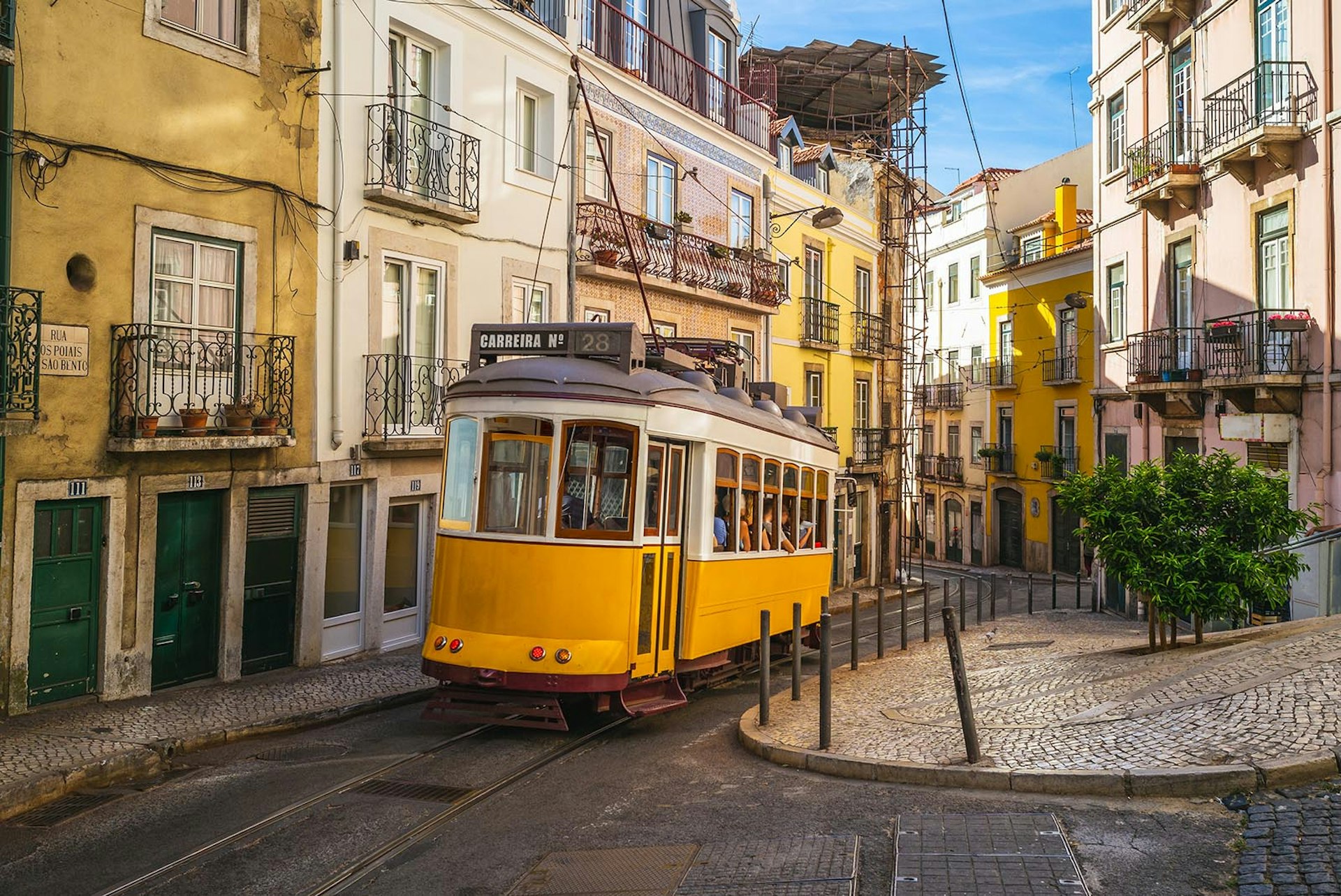 Vintage yellow Tram #28 weaving through the city streets of Lisbon, Portugal