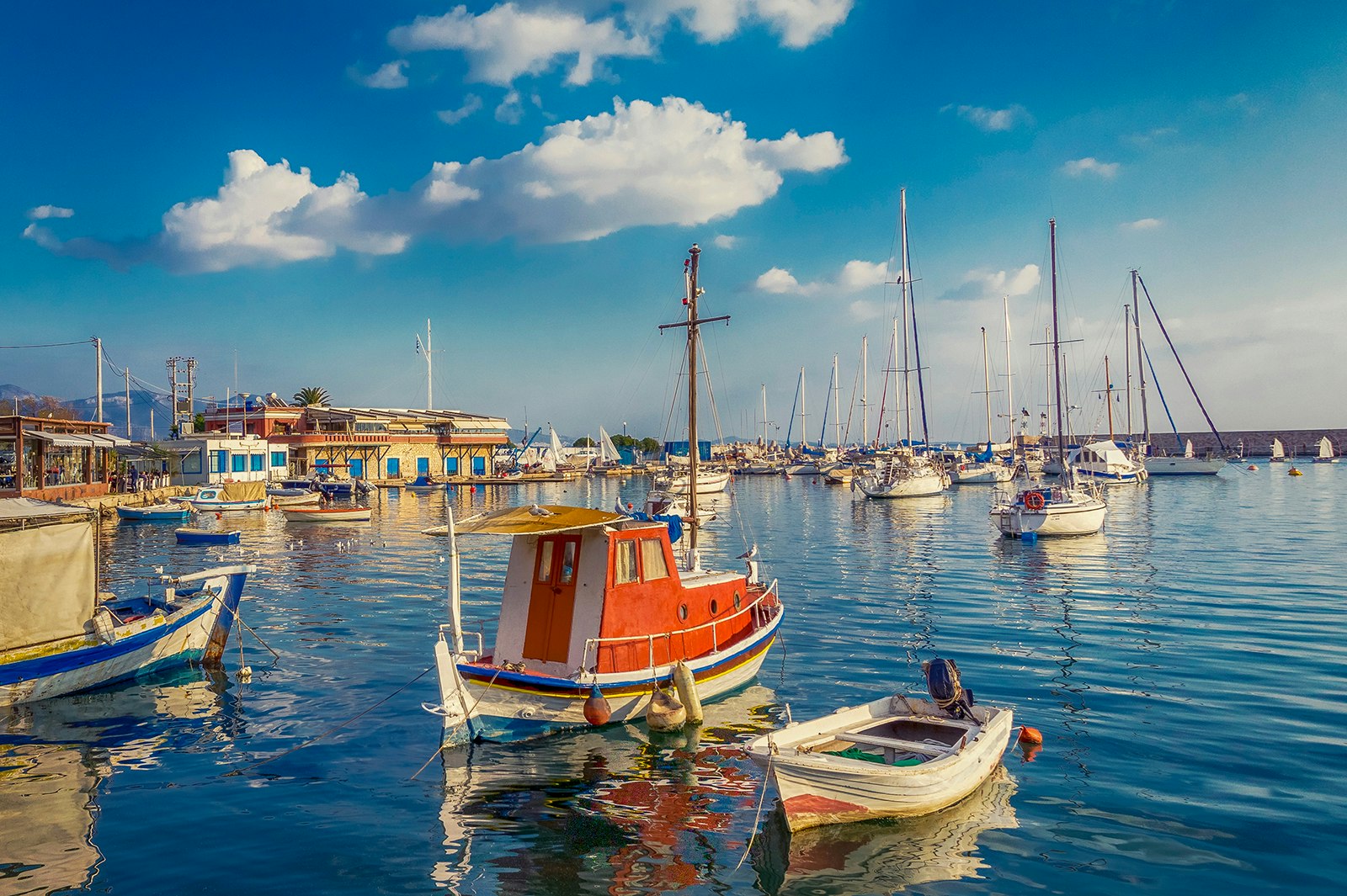 Sailboats float in a harbor near Piraeus, Greece, on a sunny day. 