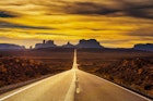 Features - Desert road leading to Monument Valley at sunset