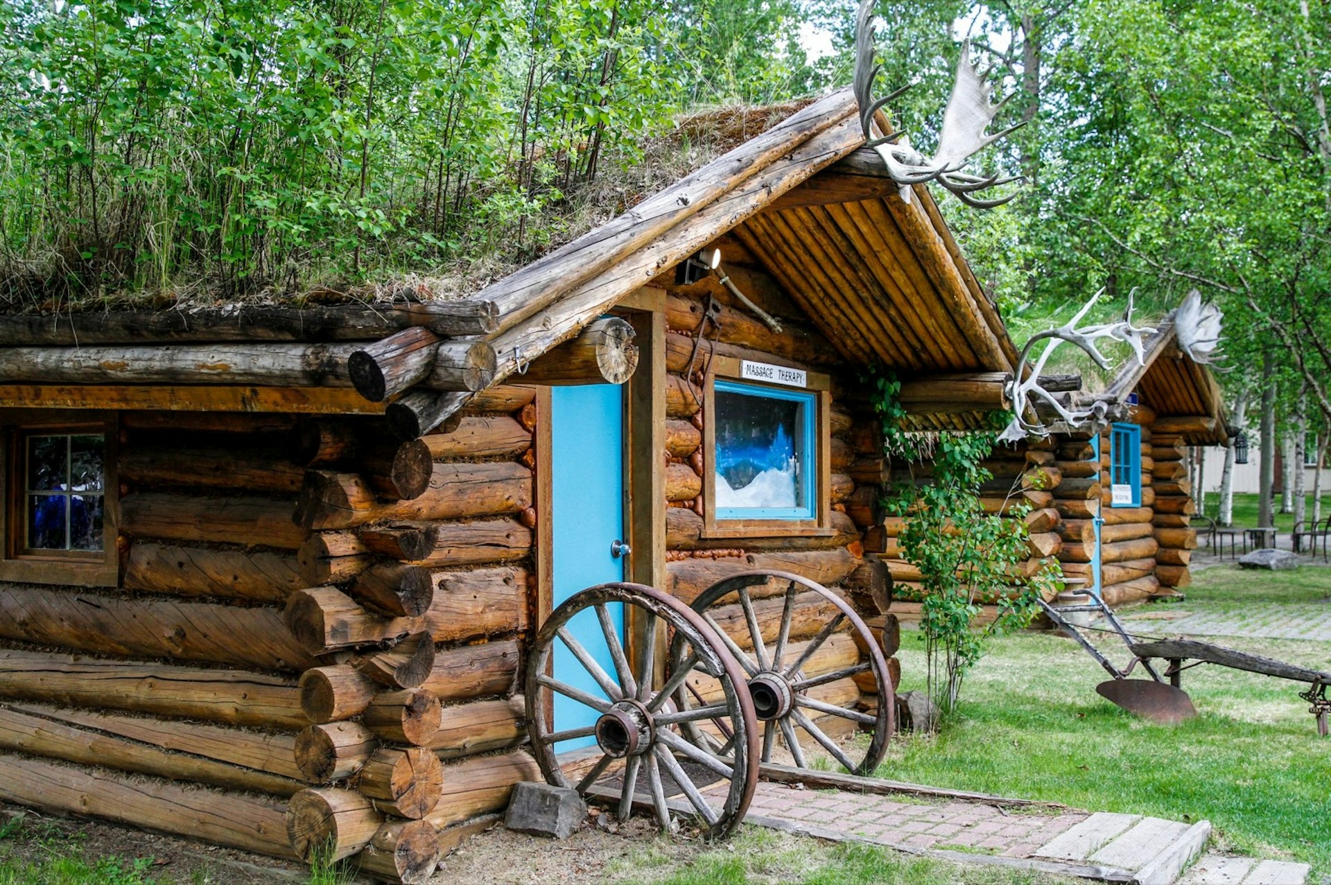 Small log cabins with wagon wheels framing the doors mark the manicured grounds of the Chena Hot Springs resort