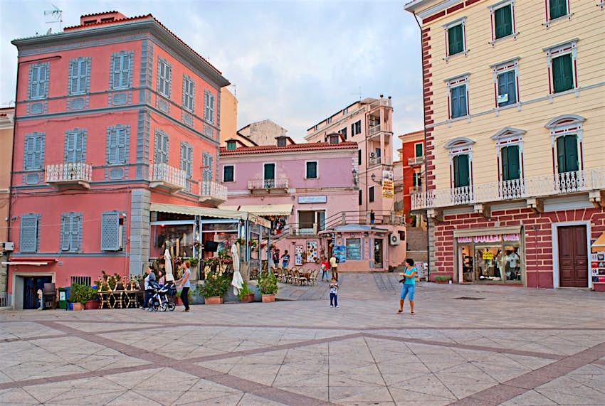 Pastel buildings surrounding a plaza; best things to do in Sardinia