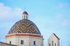 A colorful dome roof under a blue sky; best things to do in Sardinia