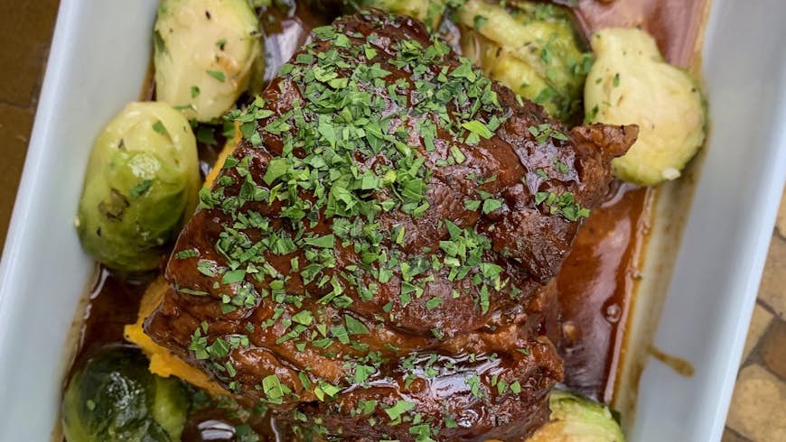 An overhead shot of a pork shoulder with brussels sprouts; weekend in Napa