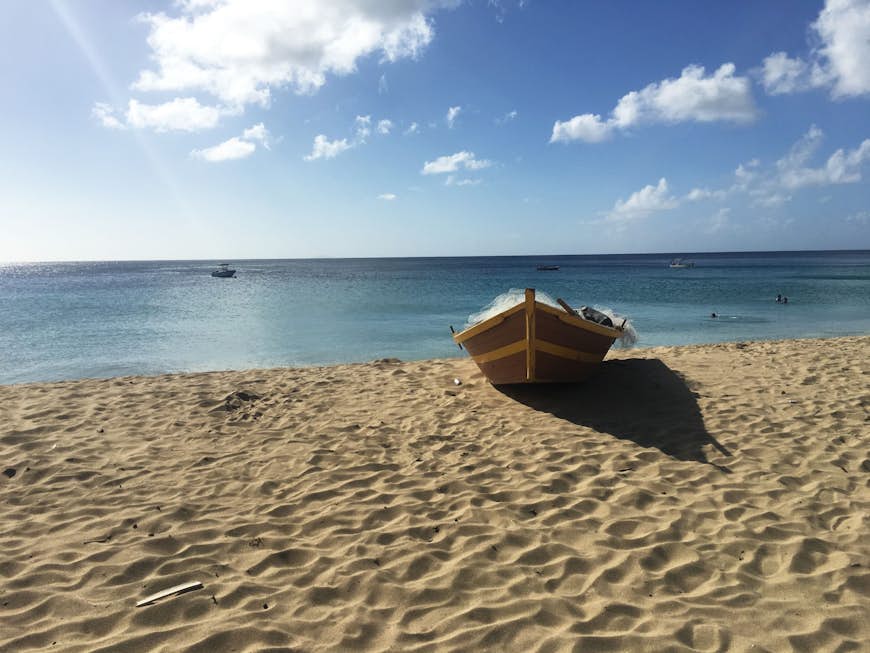 A single boat rests on the sandy shore next to a beach; best beaches Puerto Rico 