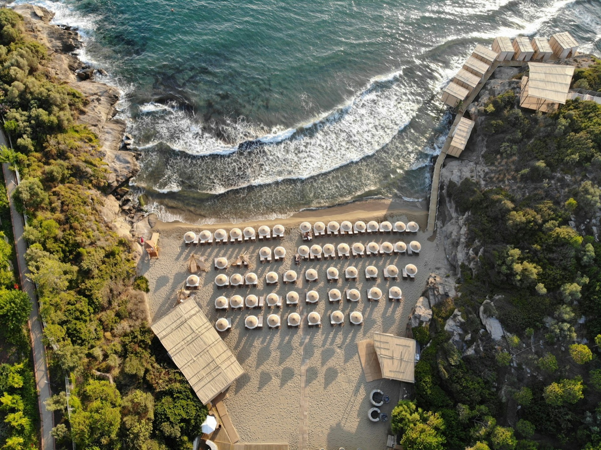 Birds'-eye view of a small beach covered with umbrellas; all-inclusive resort adventures