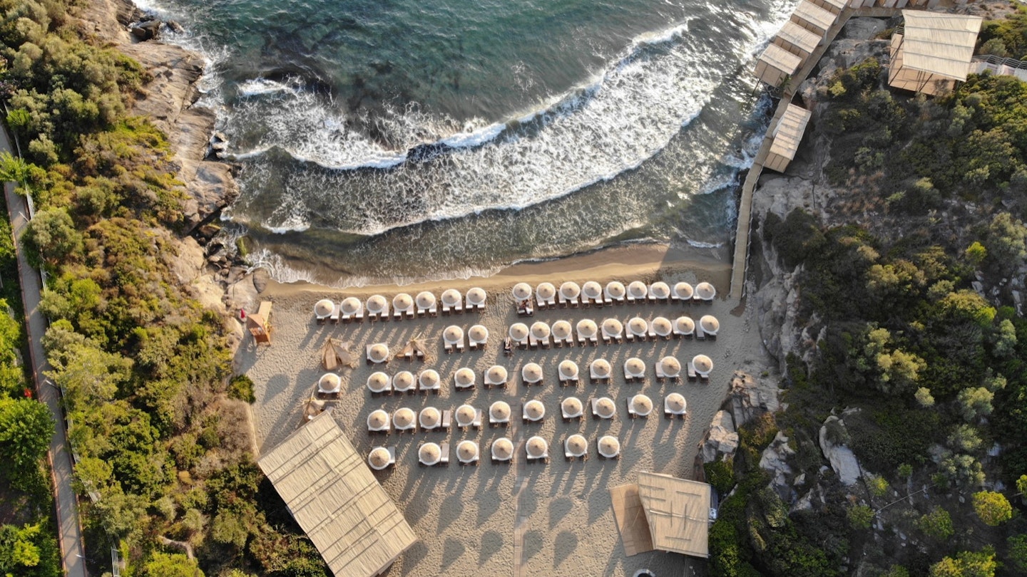 Birds'-eye view of a small beach covered with umbrellas
