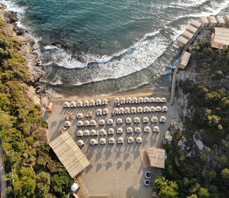 Birds'-eye view of a small beach covered with umbrellas