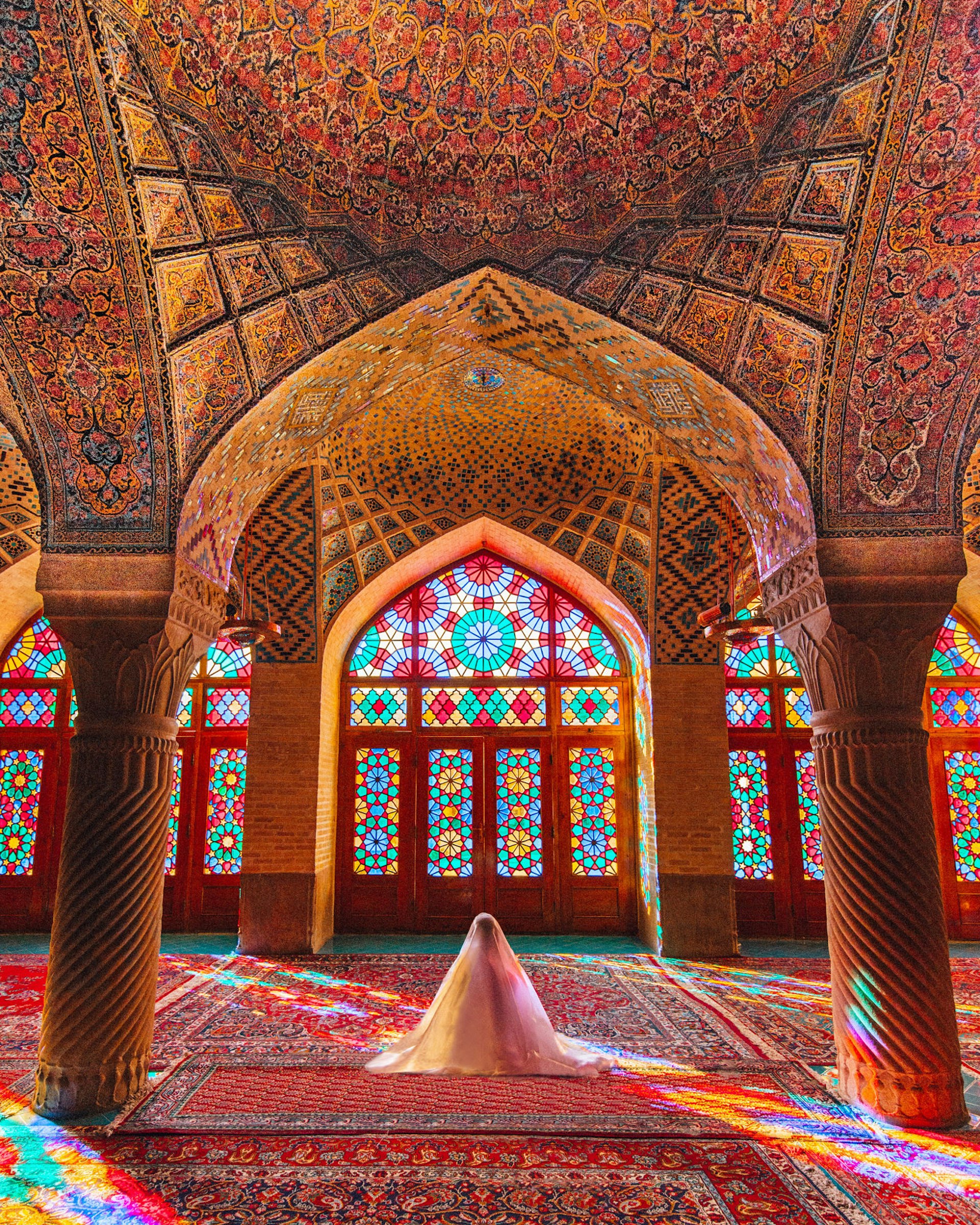 Symmetry looks great on Instagram; inside the colourful Nasir-ol-molk Mosque in Iran; there is an intricately patterned red carpet, and columns support a vaulted ceiling adorned with astonishingly detailed tilework. In the centre someone is praying covered in a white veil.