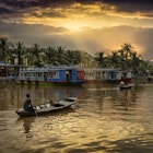 Boats on the river as the sun sets over palm tree. A perfect weekend in Hoi An