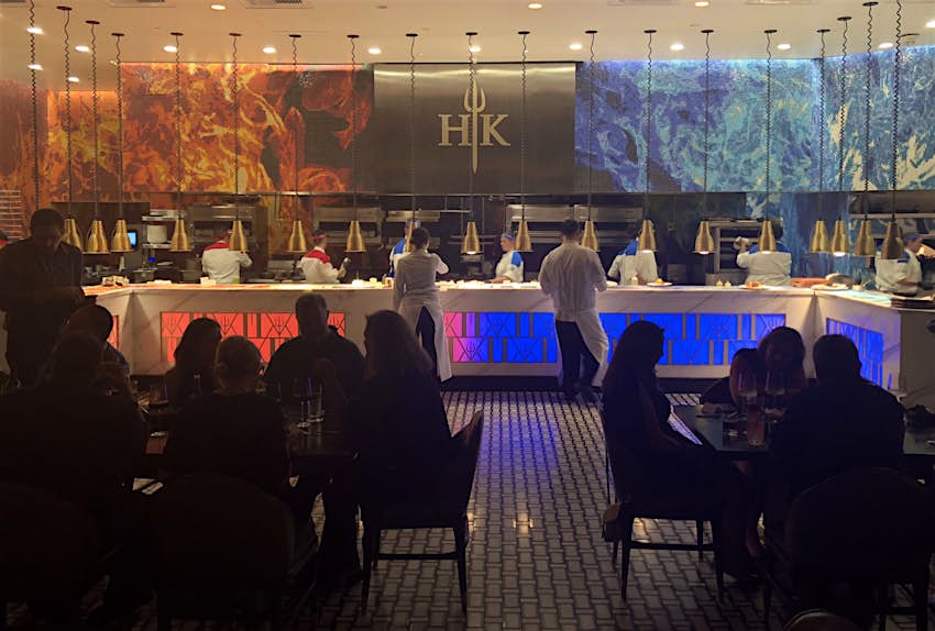 Red and blue flames mark a mural above a long kitchen as diners sit in the dark and waiters move back and forth at a celebrity chef restaurant in Las Vegas