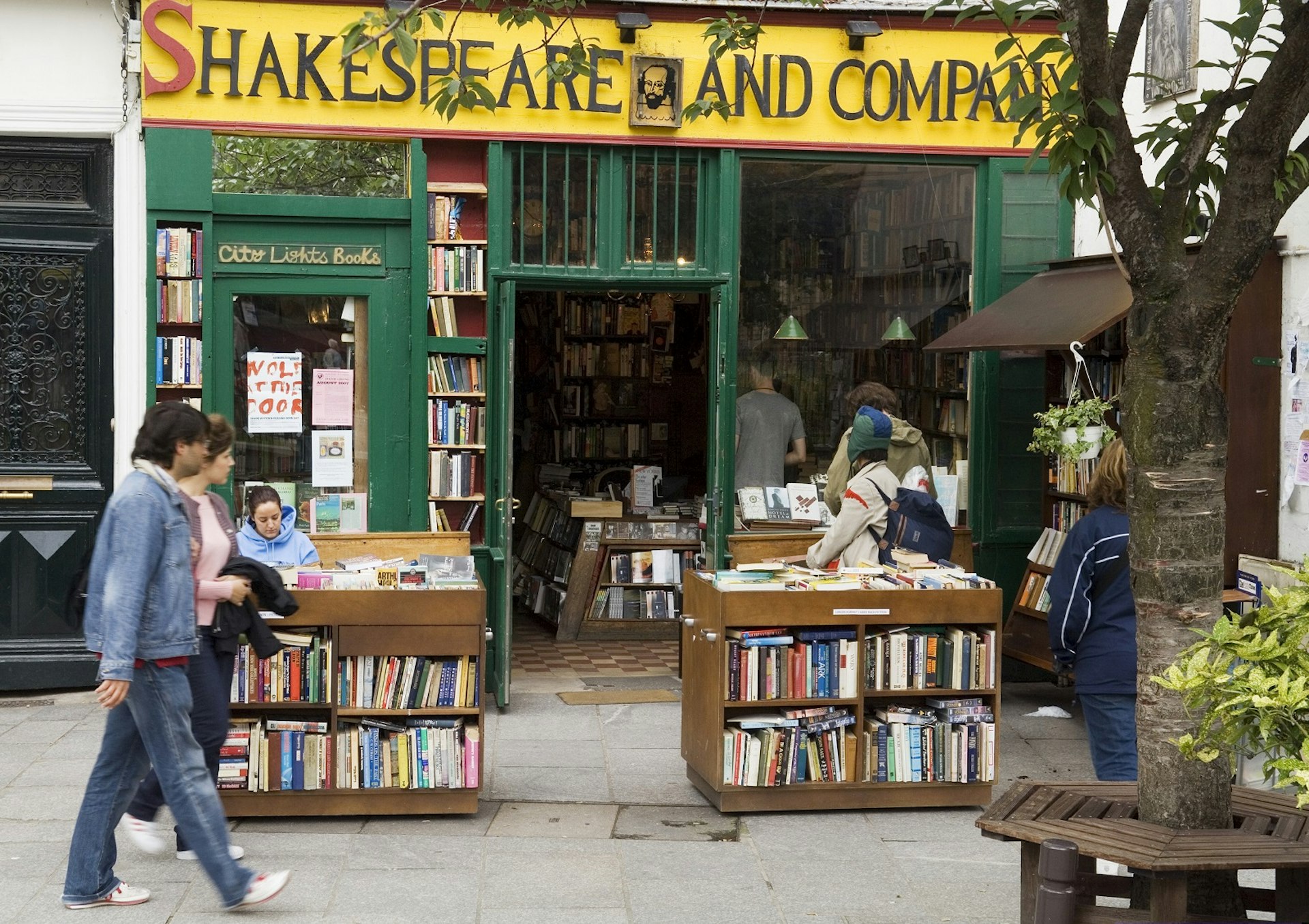 Exterior of the book shop, with several people sat outside reading or browsing the books on display
