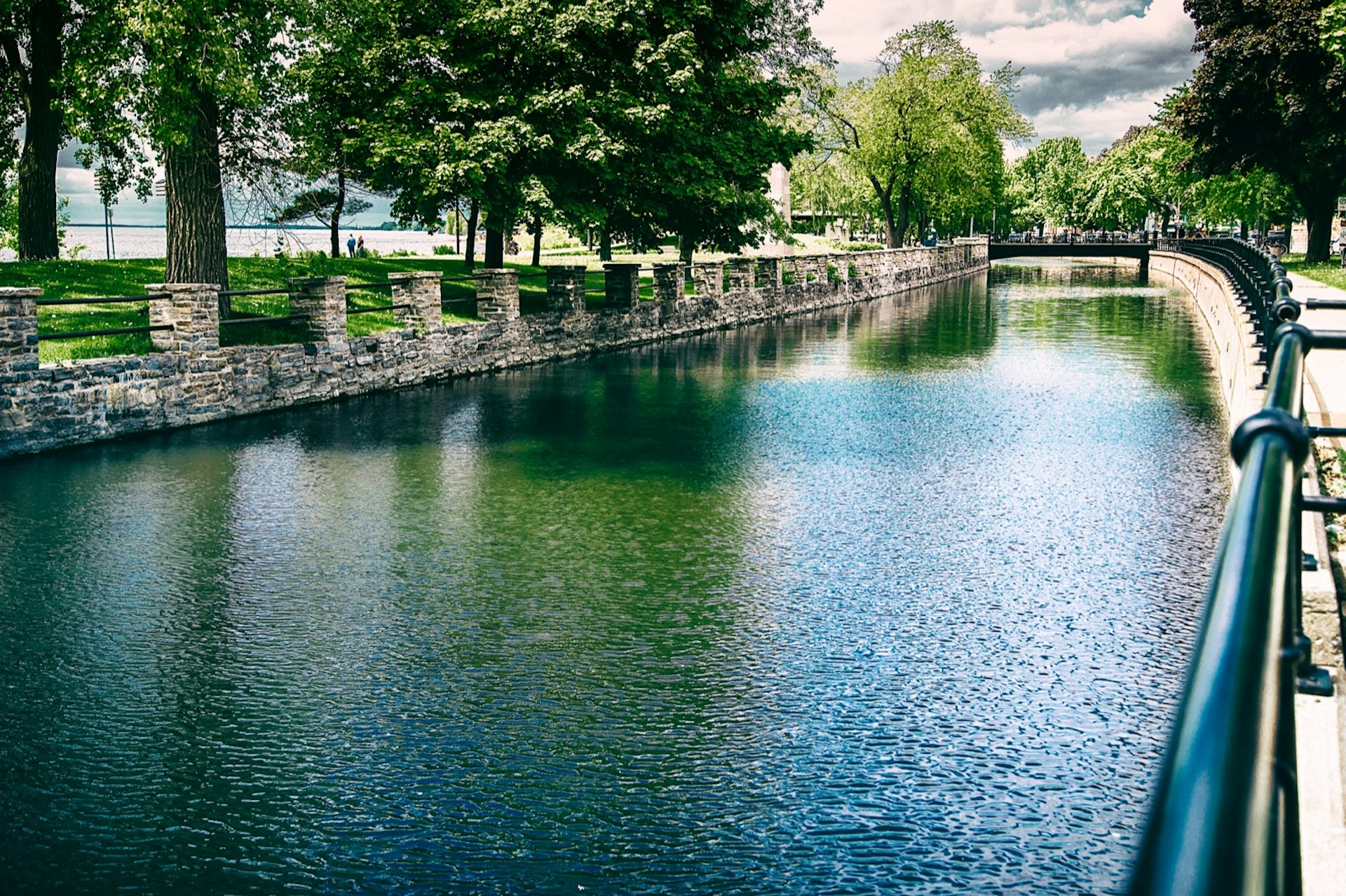 A lovely green canal curves into the distance with trees reflected in the water; Perfect Weekend in Montreal