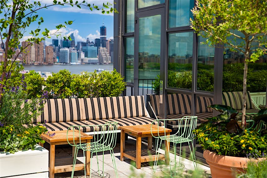Features - Lemons_6094-4b49869a44c8 A bench surrounded by potted plants on a rooftop bar in New York City