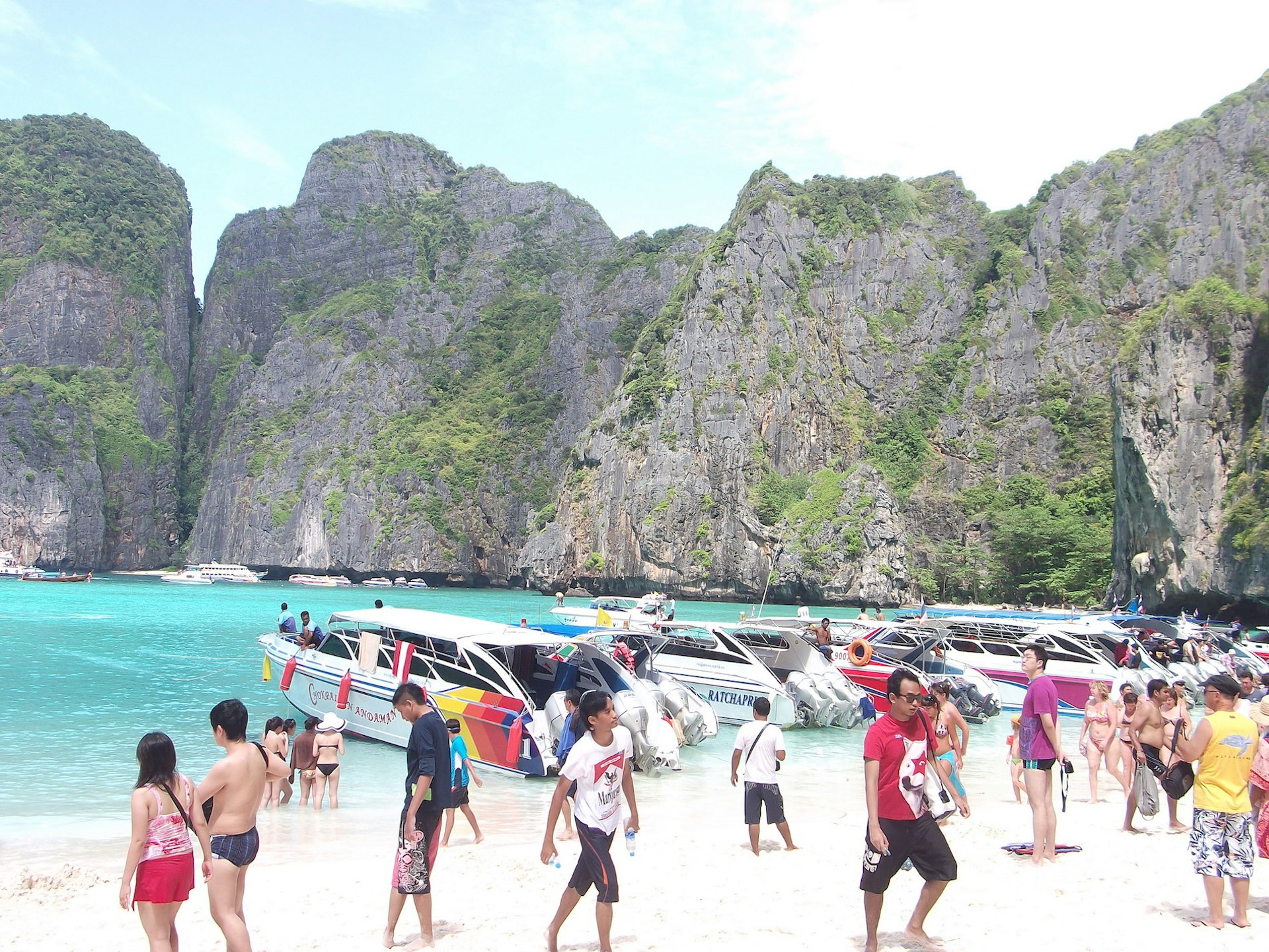 A beautiful cove is filled with speedboats and tourists in Thailand