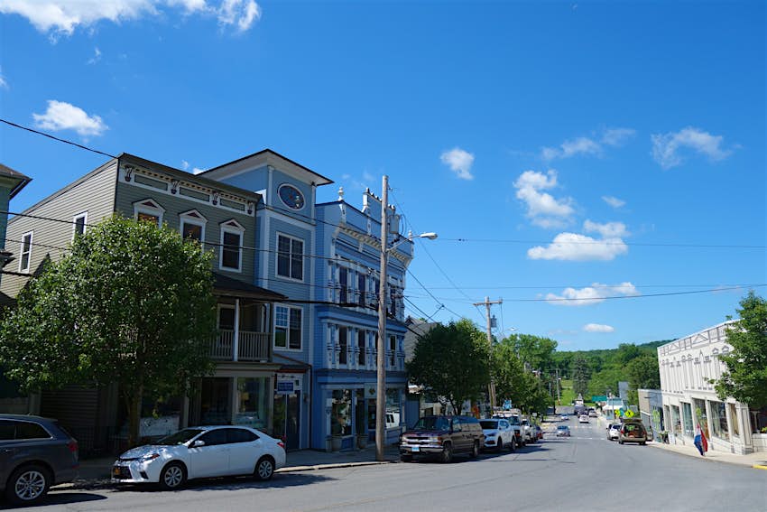 A small downtown street, with blue skies above; summer trips from New York City