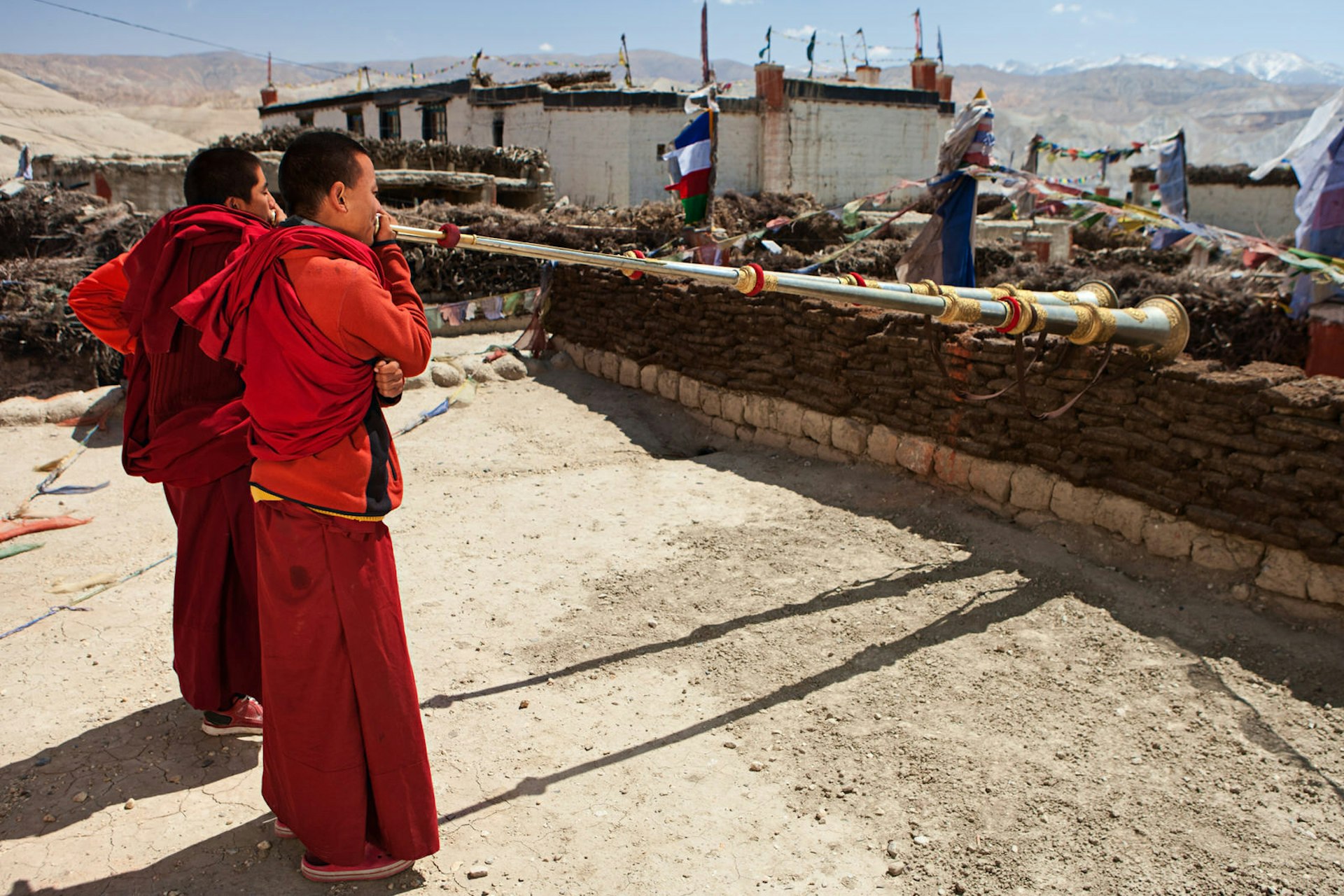 Monks blow Tibetan horns in Lo Manthang, capital of Mustang