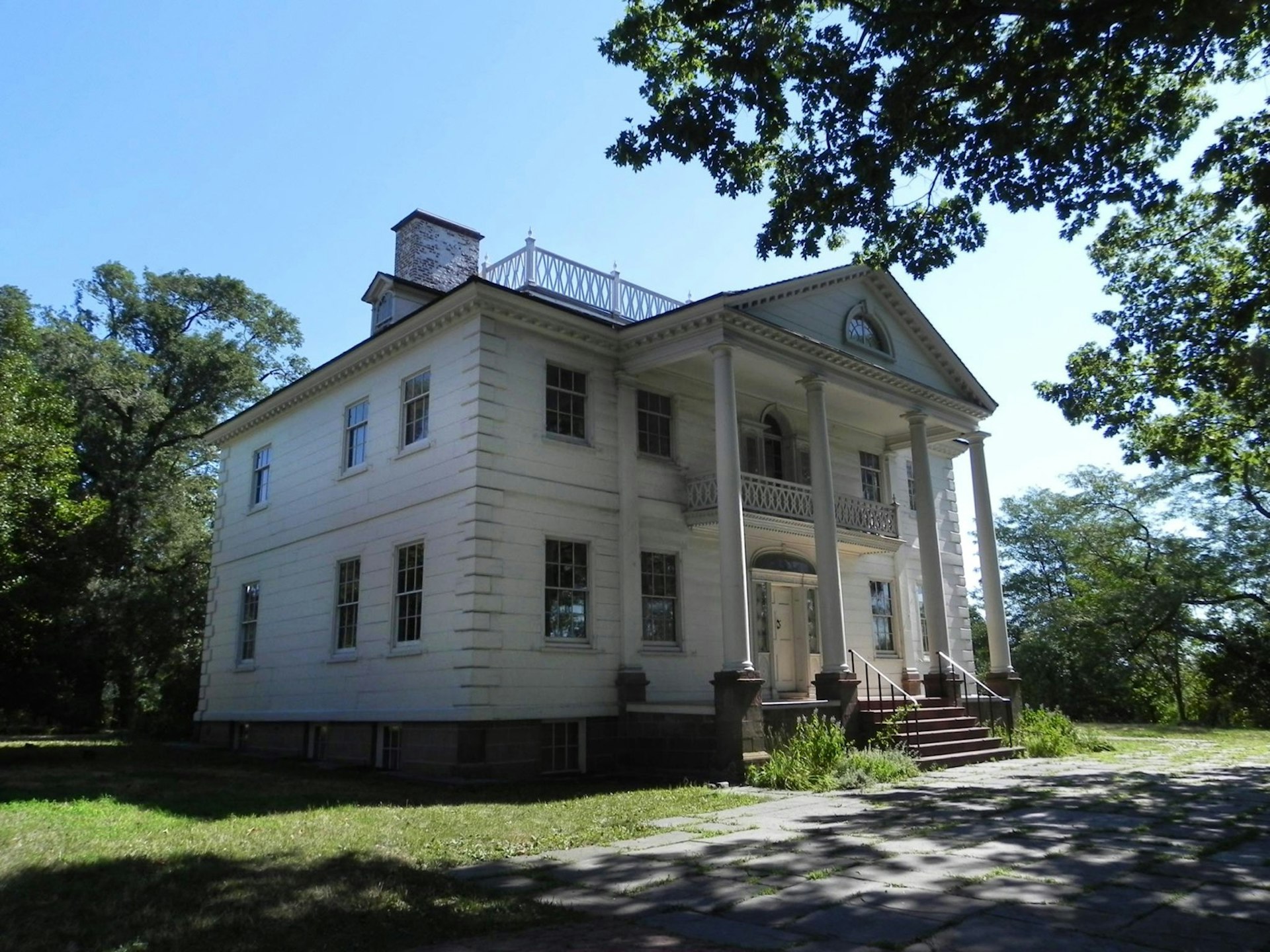 The exterior of the Morris-Jumel Mansion under a blue sky; historic homes