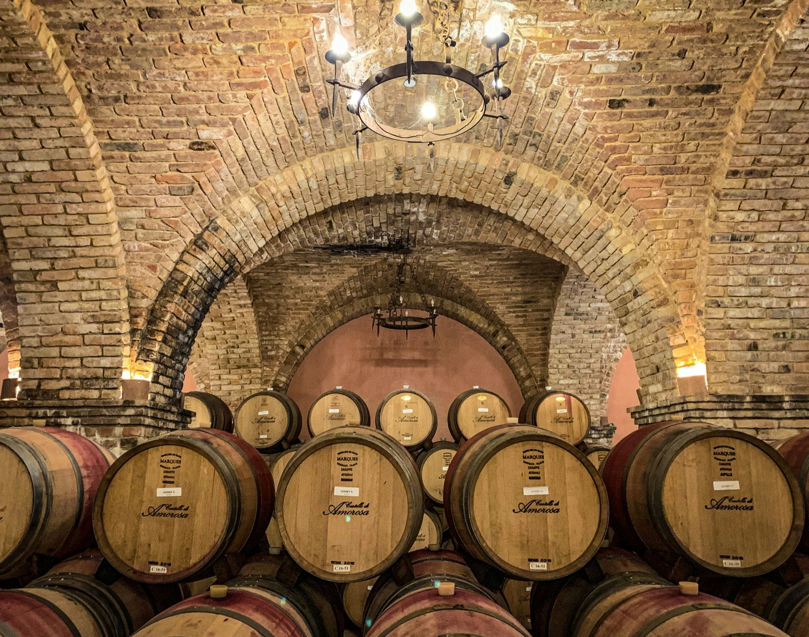 Rows of stacked barrels in a stone cellar, a common way of aging wine in California wine country