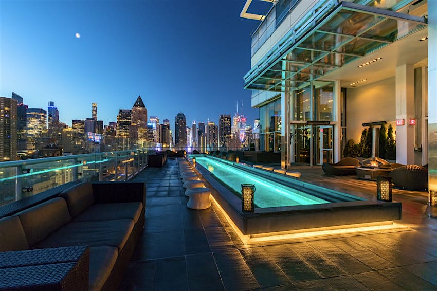 A rooftop pool, with a skyline of NYC in the background; best rooftop bars in New York City