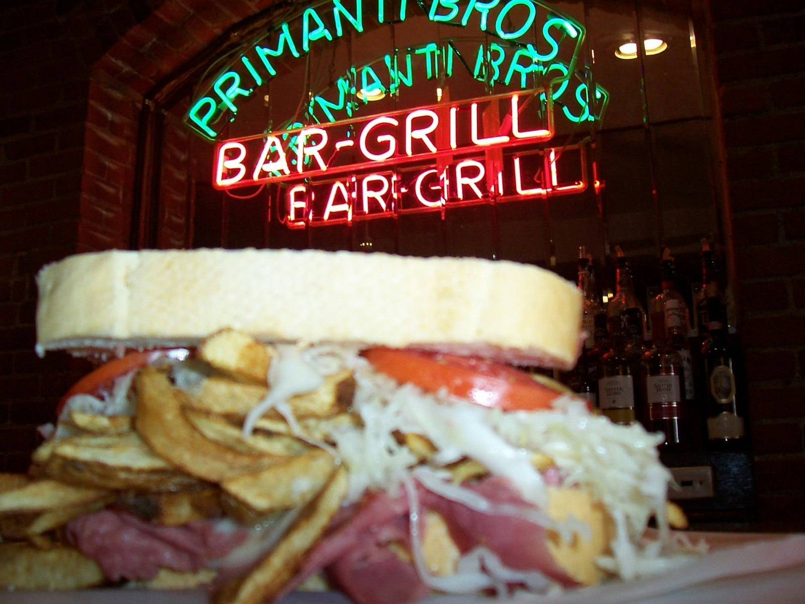 A sandwich with the Primanti Brothers neon sign in the background