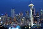 The skyline of seattle is seen in early evening, with lights on the space needle and various other buildings. Perfect weekend in Seattle