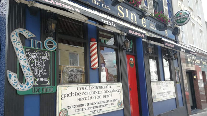Sin É pub, housed in a blue building with a red door and signs advertising its live music.