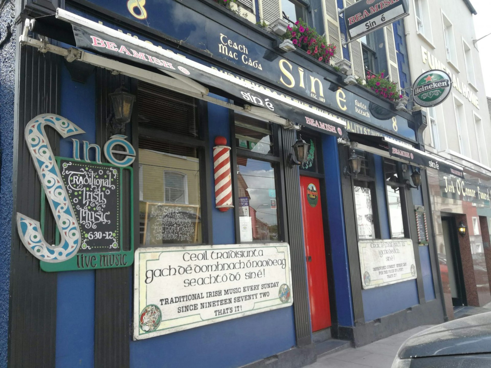 Sin É pub, housed in a blue building with a red door and signs advertising its live music.