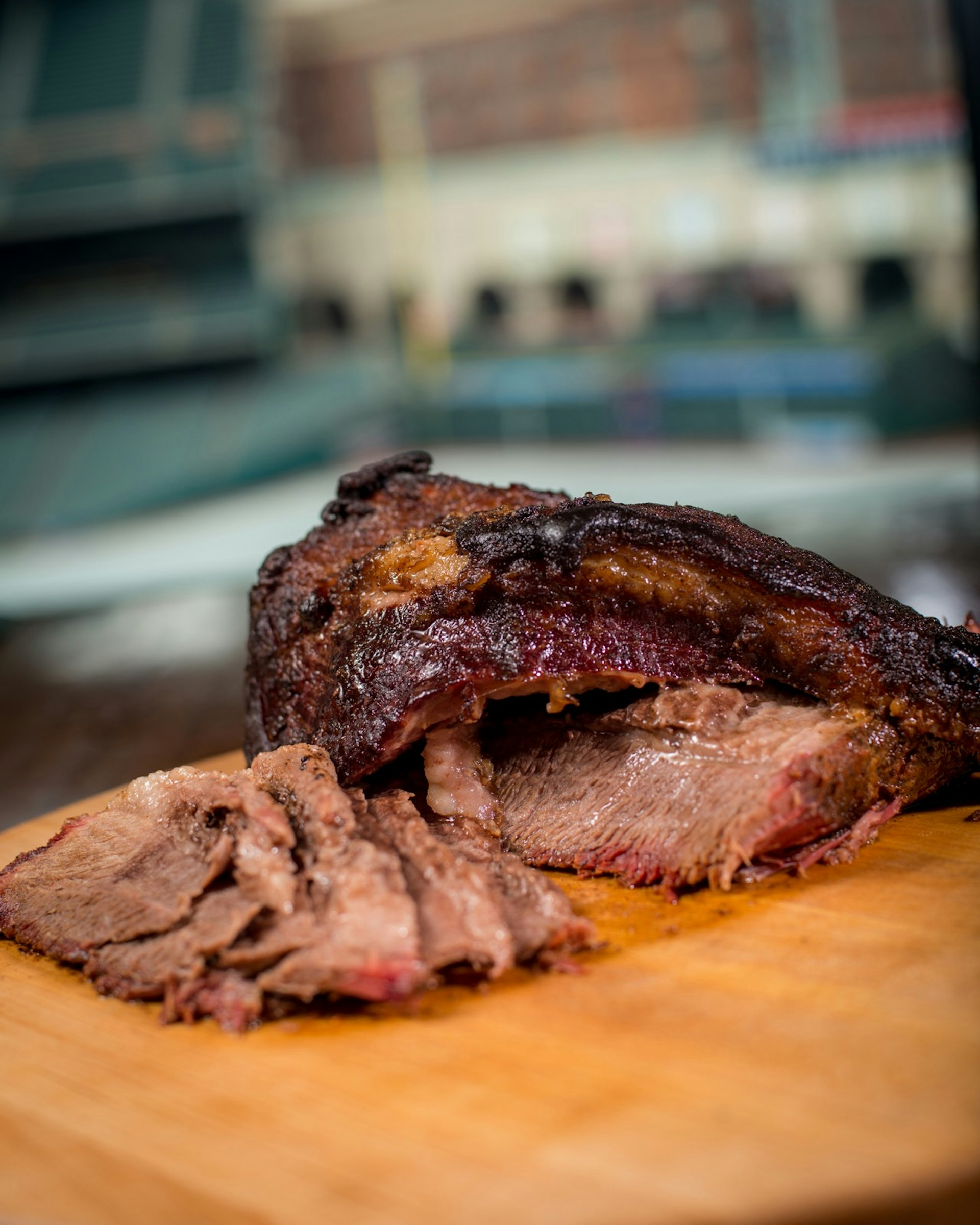 Smoked brisket sliced and fanned out on a wooden cutting board, the best kind of ballpark food