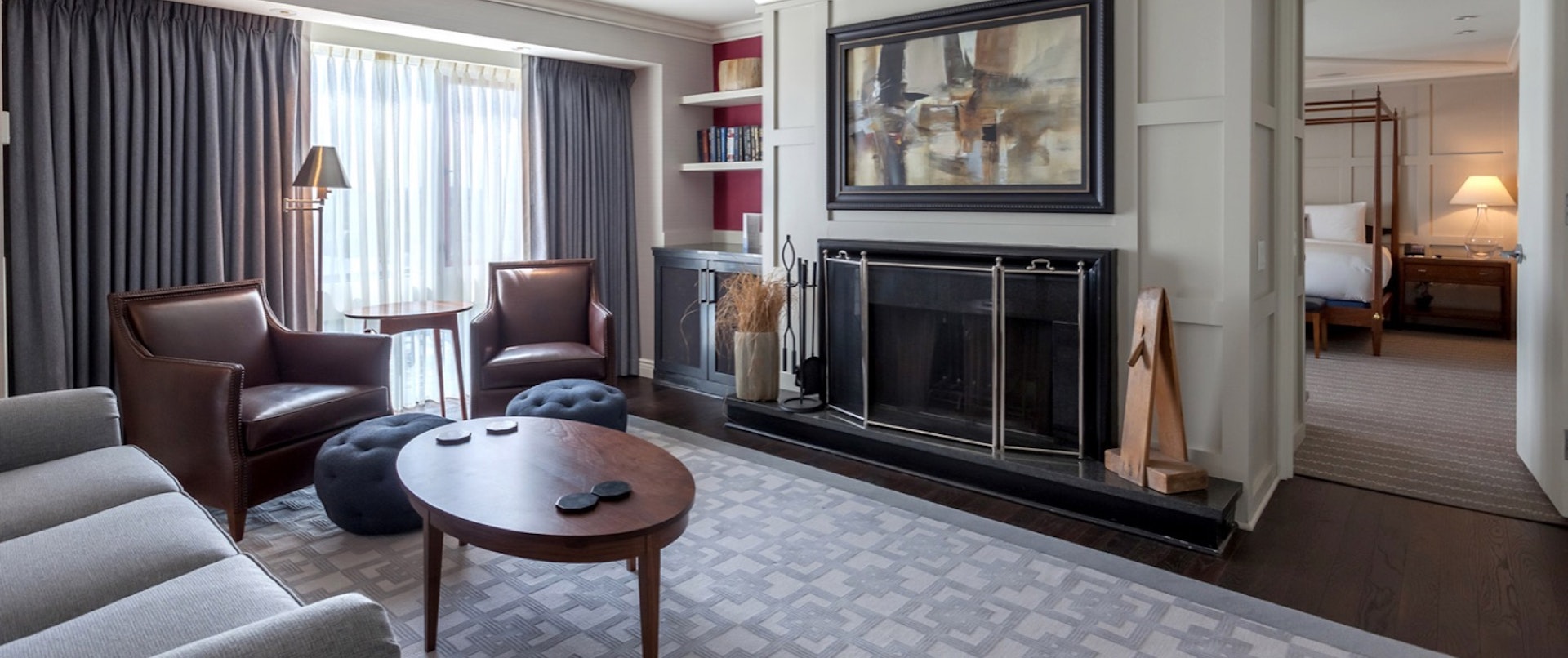 Inside the Charles Hotel presidential suite, with a couch, chairs and coffee table in front of a fire place