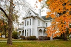 The white facade of the Truman House surrounded by orange leaves; historic homes