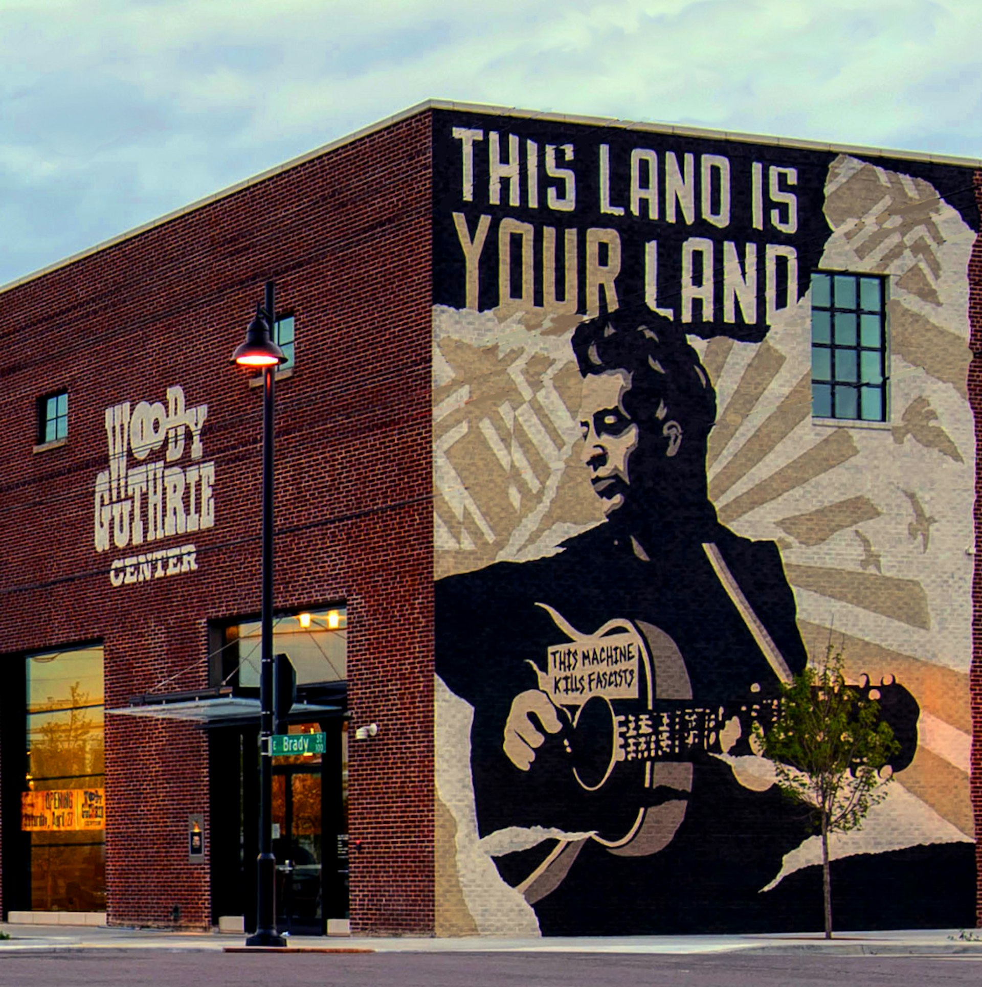 A large mural depicts Woody Guthrie and the phrase 'This land is your land' on the side of the center. USA museums for music lovers